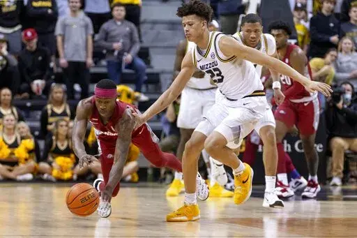 Arkansas' Davonte Davis, left, dives for the ball in front of Missouri's Trevon Brazile, right, during the first half of an NCAA college basketball game Tuesday, Feb. 15, 2022, in Columbia, Mo. (AP Photo/L.G. Patterson)