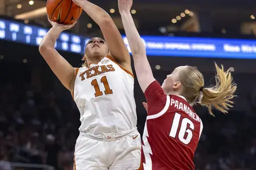 Texas forward Justice Carlton (11) looks to score over Arkansas forward Pinja Paananen (16) during the first half of an NCAA college basketball game, Sunday, Jan. 5, 2025, in Austin, Texas. (AP Photo/Stephen Spillman)
