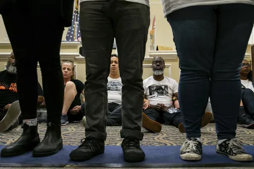 Dozens of activists stage a sit-in outside Florida Gov. Ron DeSantis' office and force people to step over them to reach DeSantis' office as they speak out against the governor and his policies, Wednesday, May 3, 2023, in Tallahassee, Fla. Florida Republicans on Wednesday approved bills to ban diversity programs in colleges and prevent students and teachers from being required to use pronouns that don't correspond to someone's sex, building on top priorities of the Republican governor. (Alicia D