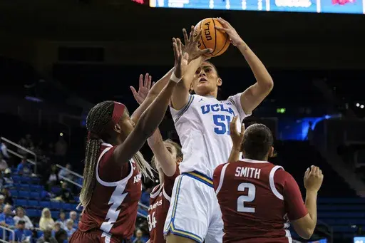 UCLA center Lauren Betts (51) looks to shoot over Arkansas players during the first half of an NCAA college basketball game Sunday, Nov. 17, 2024, in Los Angeles. (AP Photo/William Liang)