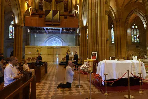 The coffin of Cardinal George Pell lays in state at St. Mary's Cathedral in Sydney, Wednesday, Feb. 1, 2023. Mourners paid their respects to Cardinal George Pell who lay in state in a Sydney cathedral on Wednesday as police sought a court order to prevent protesters from disrupting his funeral. (AP Photo/Rick Rycroft, Pool)
