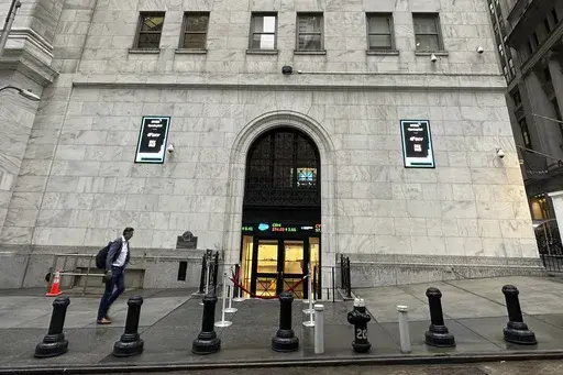 A man approaches an entrance to the New York Stock Exchange on Sept. 26, 2024, in New York. (AP Photo/Peter Morgan, File)