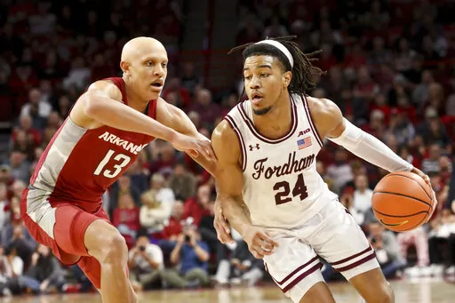Fordham guard Antrell Charlton (24) tries to drive past Arkansas guard Jordan Walsh (13) during the first half of an NCAA college basketball game Friday, Nov. 11, 2022, in Fayetteville, Ark. (AP Photo/Michael Woods)