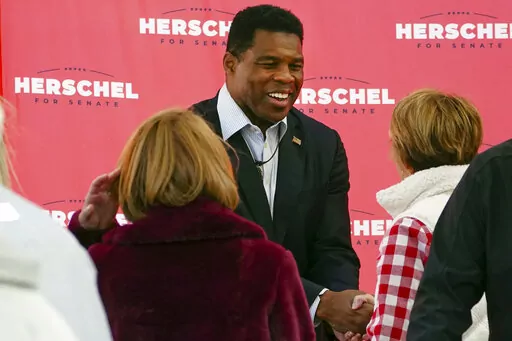 Herschel Walker, Republican candidate for U.S. Senate in Georgia, greets supporters during a campaign rally Oct. 18, 2022, in Atlanta. Walker campaigns for the U.S. Senate as a champion of free enterprise and advocate for the mentally ill, felons and others. And the Georgia Republican has called for policies that blend those priorities. Yet Walker, through a major chicken processor that he touts as a principal partner to one of his primary businesses,  has benefited from years of unpaid labor b