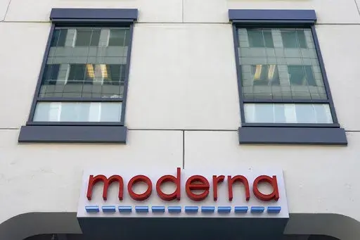 In this Dec. 15, 2020, file photo, a sign for Moderna, Inc. hangs on its headquarters in Cambridge, Mass.  Moderna's experimental COVID-19 vaccine that combines its original shot with protection against the omicron variant appears to work, the company announced Wednesday, June 8, 2022.  COVID-19 vaccine makers are studying updated boosters that might be offered in the fall to better protect people against future coronavirus surges.(AP Photo/Elise Amendola, File)