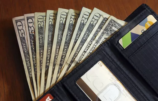 In this June 15, 2018, file photo, cash is fanned out from a wallet in North Andover, Mass. Parenting comes with many responsibilities, and one is raising financially independent kids. But adult kids sometimes still need financial support. Financially supporting adult kids is a kind thing to do but can have downsides if you’re not financially secure. Not only can it affect your retirement savings, but it also may strain your relationship with your kids. (AP Photo/Elise Amendola, File)