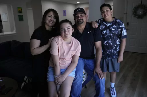 Mayah Zamora, second from left, a survivor of the mass shooting at Robb Elementary in Uvalde, Texas, poses for a photo with her mom Christina, left, dad Ruben, and brother Zach, right, at their home in San Antonio, Tuesday, June 27, 2023. Besides medical bills and the weight of trauma and grief, mass shooting survivors and their family members contend with scores of other changes that show how thoroughly their lives have been upended by violence. (AP Photo/Eric Gay)