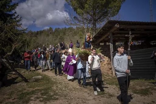 Local residents take part in a procession carrying a replica of the Our Lady of the Torrents, a virgin historically associated with drought, in l'Espunyola, north of Barcelona, Spain, Sunday, March 26, 2023. Farmers and parishioners gathered Sunday at the small hermitage of l'Espunyola, a rural village in Catalonia, to attend a mass asking the local virgin Our Lady of the Torrents for rain. Prayers and hymns were offered to ask for divine intervention in solving the earthly crisis. (AP Photo/Emi