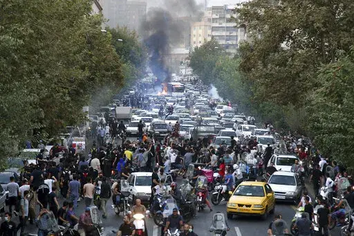 In this photo taken by an individual not employed by the Associated Press and obtained by the AP outside Iran, protesters chant slogans during a protest over the death of a woman who was detained by the morality police, in downtown Tehran, Iran, Sept. 21, 2022. Iran’s Foreign Ministry said Sunday, Sept. 25, 2022, that it summoned Britain's ambassador to protest what it described as a hostile atmosphere created by London-based Farsi language media outlets. The move comes amid violent unrest in 