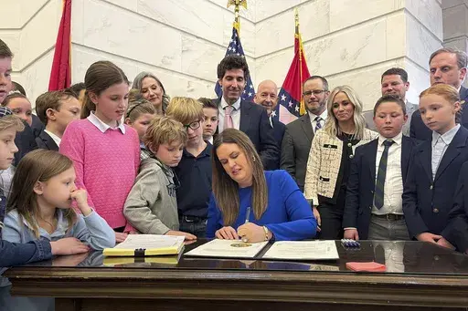Arkansas Gov. Sarah Huckabee Sanders signs an education overhaul bill into law on March 8, 2023, at the state Capitol in Little Rock, Ark. Four Arkansas residents filed a lawsuit on Friday, June 7, 2024, challenging the school voucher program created by the bill, saying it violates the state constitution's protections for educational funding. (AP Photo/Andrew DeMillo, File)