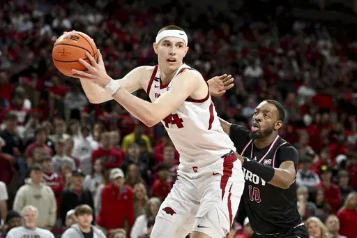 Arkansas forward Zvonimir Ivisic (44) drives past Troy forward Jerrell Bellamy (10) during the second half of an NCAA college basketball game Wednesday, Nov. 13, 2024, in Fayetteville, Ark. (AP Photo/Michael Woods)