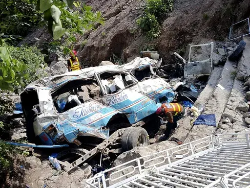 Rescue workers look for the victims and wounded passengers from the wreckage of a bus that fell into a ravine, near Kahuta, Pakistan, Sunday, Aug. 25, 2024. (AP Photo/Mohammad Yousaf)