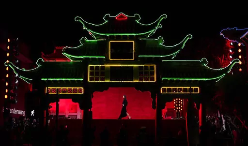 A model is framed in the East Gate at Old Chinatown Plaza as she walks the runway at fashion designer Alexander Wang's "Fortune City" runway show and party celebrating Asian-American culture, Tuesday, April 19, 2022, in Los Angeles. (AP Photo/Chris Pizzello)