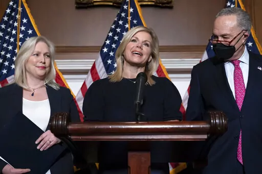 Former Fox News anchor Gretchen Carlson, center, celebrates with Sen. Kirsten Gillibrand, D-N.Y., left, and Senate Majority Leader Chuck Schumer, D-N.Y., after Congress gave final approval to legislation guaranteeing that people who experience sexual harassment at work can seek recourse in the courts, during a news conference at the Capitol in Washington, Thursday, Feb. 10, 2022. Since her 2016 sexual harassment lawsuit against then Fox News Chairman and CEO Roger Ailes, Carlson has worked to ba