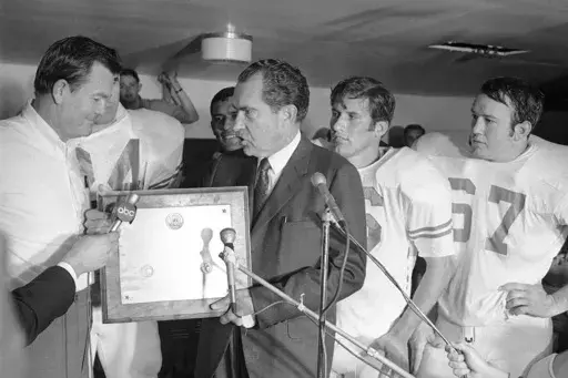 President Richard Nixon presents a plaque to Texas football coach Darrell Royal, naming the Longhorns the No. 1 college football team in college football as linebacker Glen Halsell (67) and quarterback James Street (16) watch, Dec. 6, 1969. (AP Photo/File)