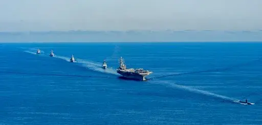 In this photo provided by the South Korea Defense Ministry, the USS Ronald Reagan aircraft carrier, second from right, participates in a joint anti-submarine drill among South Korea, the United States and Japan in waters off South Korea's eastern coast in South Korea, Friday, Sept. 30, 2022. South Korea, U.S. and Japanese warships launched their first trilateral anti-submarine drills in five years on Friday, after North Korea renewed missile tests this week in an apparent response to bilateral t