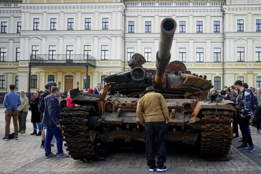 A man looks at a destroyed Russian tank placed as a symbol of war in downtown Kyiv, Ukraine, May 23, 2022. A new report from NewsGuard, a tech firm that tracks disinformation has identified 250 websites actively working to spread Kremlin disinformation.(AP Photo/Natacha Pisarenko, File)