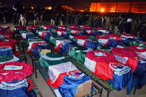 In this handout photo released by Pakistan's Police Department, security officials gather for funeral prayers of police officer, who were killed in the suicide bombing inside a mosque, in Peshawar, Pakistan, Monday, Jan. 30, 2023. A suicide bomber struck Monday inside a mosque in the northwestern Pakistani city of Peshawar, killing multiple people and wounding scores of worshippers, officials said. (Pakistan's Police Department via AP)