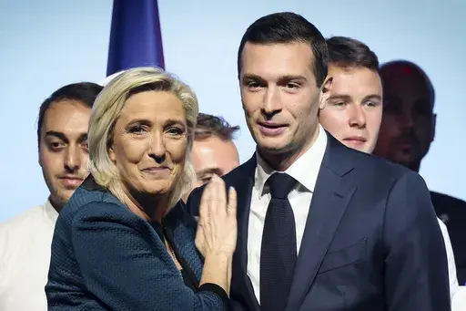 Leader of the French far-right National Rally Marine Le Pen, left, and lead candidate of the party for the upcoming European election Jordan Bardella during a political meeting on June 2, 2024 in Paris. At just 28 years old, Jordan Bardella has led the French far right to a landslide victory in the European Parliament election in June. After voters propelled Marine Le Pen's National Rally to a strong lead in the first round of national legislative elections on Sunday, Bardella has turned to rall