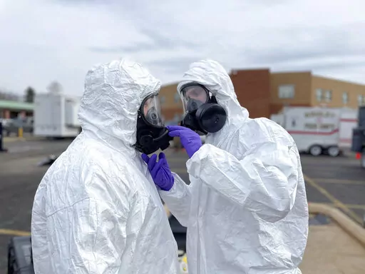 This photo provided by the Ohio National Guard, ONG 52nd Civil Support Team members prepare to enter an incident area to assess remaining hazards with a lightweight inflatable decontamination system (LIDS) in East Palestine, Ohio, Tuesday, Feb. 7, 2023. Authorities say air monitoring hasn’t detected dangerous levels of fumes in communities where crews released and burned toxic chemicals from a derailed train. But they said Tuesday that Ohio and Pennsylvania residents living close to the wrecka
