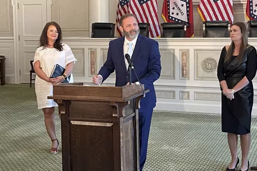 Cody Hiland speaks at the old state Supreme Court chamber at the Arkansas Capitol in Little Rock, Ark., Monday, July 3, 2023, after Gov. Sarah Huckabee Sanders, right, announced his appointment to the Supreme Court. Hiland will fill the vacancy of Justice Robin Wynne, who died in June. (AP Photo/Andrew DeMillo)