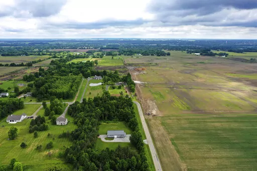This aerial image taken with a drone on June 9, 2022 shows a portion of land in Johnstown, Ohio, where Intel plans to build two new processor factories. The houses on the left are up for demolition. Intel Corp. plans a Sept. 9 groundbreaking for its planned $20 billion Ohio semiconductor operations with President Joe Biden giving remarks, the company and the the White House said Thursday, Aug. 25, 2022. (AP Photo/Gene J. Puskar, File)
