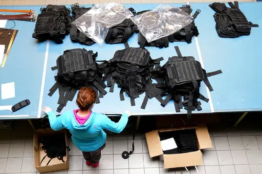 A Ukrainian worker sorts newly produced body armor at a leatherwork shop in Prague, Czech Republic, Thursday, April 21, 2022. A Czech leatherwork company that makes a wide variety of handmade products — travel bags, wallets and belts — never intended to add personal protective gear that would save lives in a war to its offerings. But the Russian invasion of Ukraine has changed all that. After Russian troops launched their assault, Tlusty & Co. has hired 15 Ukrainian refugees to help it manuf