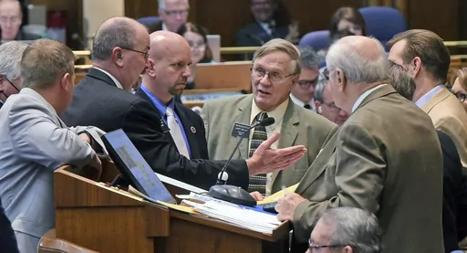 FILE- North Dakota House Majority Leader Rep. Chet Pollert, R-Carrington, second from left, gestures toward House Speaker Rep. Kim Koppelman, R-West Fargo, far right, prior to the start of the floor session and votes on whether to override three vetoes by Gov. Doug Burgum, which includes a bill restricting transgender girls from participating in public elementary and secondary school sports, Thursday, April 22, 2021, at the state Capitol in Bismarck, N.D. U.S. states with laws restricting what b