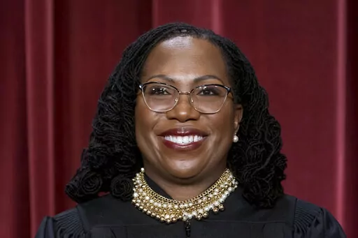 Associate Justice Ketanji Brown Jackson stands as she and members of the Supreme Court pose for a new group portrait following her addition, at the Supreme Court building in Washington, Friday, Oct. 7, 2022. (AP Photo/J. Scott Applewhite)
