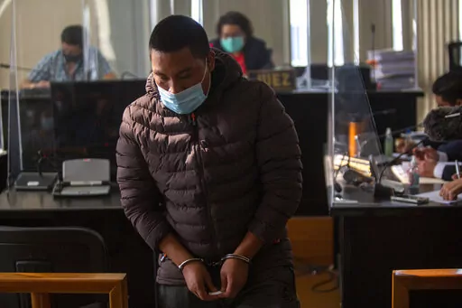 Juan Miranda, who is allegedly part of a human trafficking network, returns to his place after questioning in the courts of justice in Guatemala City, Friday, Feb. 4, 2022.  Eager to show it’s trying to slow the steady flow of its people north to the United States, Guatemala recently tripled prison sentences for migrant smugglers. (AP Photo/Oliver de Ros, File)