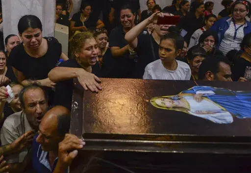 Mourners attend a memorial service for victims of a fire at a church in Greater Cairo that killed dozens on Sunday, Aug. 14, 2022. The blaze ignited at the Abu Sefein church in the densely populated neighborhood of Imbaba while a service was underway, according to the church. (AP Photo/Tarek Wajeh)