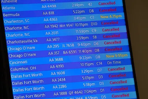 The arrivals board at the American Airlines terminal at LaGuardia Airport displays the flights that have been canceled or delayed and one that is on time, March 21, 2020, in New York. Flight delays and cancellations have bedeviled airline travel so far this year. The Transportation Department is launching a customer service dashboard to assist vacationers ahead of the travel-heavy Labor Day weekend. (AP Photo/Mary Altaffer, File)