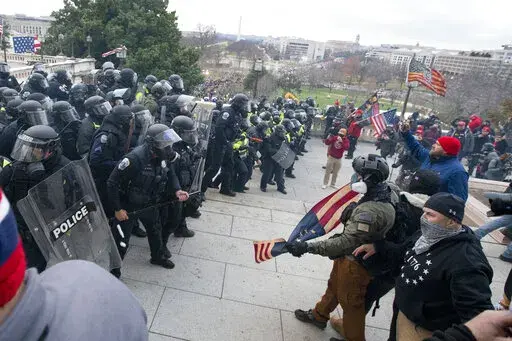Rioters face off with police at the U.S. Capitol on Jan. 6, 2021, in Washington. A growing number of Capitol riot defendants are pushing to get their trials moved out of Washington. They claim they can't get a fair trial before unbiased jurors in the District of Columbia. (AP Photo/Jose Luis Magana, File)