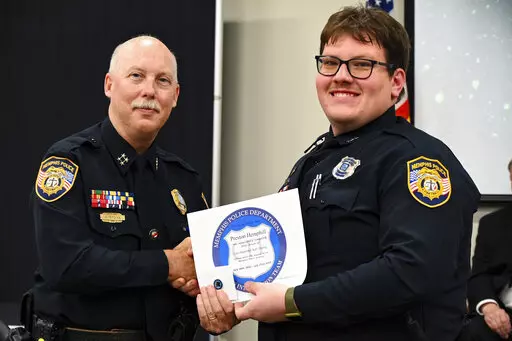 In this photo obtained from the Memphis Police Department's Facebook page, Preston Hemphill receives a certificate from Memphis Assistant Chief of Police Don Crowe after completing the training to join the department's Crisis Intervention Team on July 21, 2022. Police officials said Monday, Jan. 30, 2023, that Hemphill and another officer were relieved of duty in connection with the death of Tyre Nichols, widening the circle of punishment for the shocking display of police brutality after video 