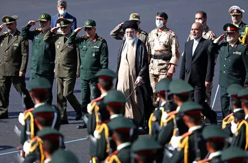 In this picture released by the official website of the office of the Iranian supreme leader, Supreme Leader Ayatollah Ali Khamenei, center, reviews a group of armed forces cadets during their graduation ceremony accompanied by commanders of the armed forces, at the police academy in Tehran, Iran, Monday, Oct. 3, 2022. Khamenei responded publicly on Monday to the biggest protests in Iran in years, breaking weeks of silence to condemn what he called “rioting” and accuse the U.S. and Israel of