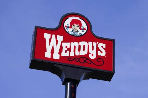 This Thursday, Feb. 25, 2021, photo shows a sign over a Wendy's restaurant in Des Moines, Iowa. Wendy’s has announced, Friday, Aug. 19, 2022, it’s pulling lettuce from sandwiches in stores in Michigan, Ohio and Pennsylvania after people eating sandwiches there reported falling ill. The Centers for Disease Control and Prevention is investigating the source of the illness.  (AP Photo/Charlie Neibergall, File)