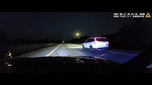 This image taken from police dash camera footage provided by the Minnesota State Patrol, shows a Minnesota trooper passing 18-year-old Sam Dutcher after the Honda Pilot he was driving began to accelerate over 100 miles per hour in western Minnesota on Tuesday, Sept. 17, 2024. The brakes and would not work and the vehicle would not shift into neutral. A trooper managed to speed in front of the Honda and told Sam by phone to crash into the rear of his squad car, allowing it to ease safely to a sto