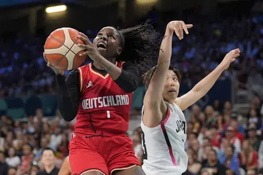 Germany's Alexis Peterson, left, shoots as Japan's Evelyn Mawuli defends during a women's basketball game at the 2024 Summer Olympics, Thursday, Aug. 1, 2024, in Villeneuve-d'Ascq, France. (AP Photo/Michael Conroy)