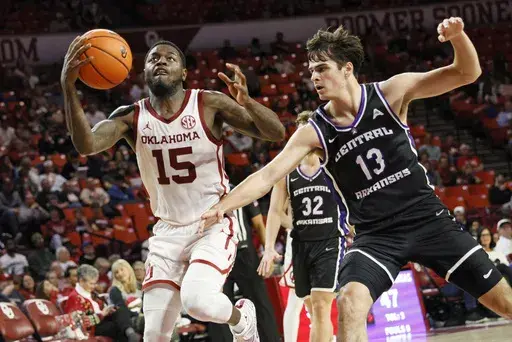 Oklahoma guard Duke Miles (15) drives next to Central Arkansas guard Ben Fox (13) during the second half of an NCAA college basketball game, Sunday, Dec. 22, 2024, in Norman, Okla. (AP Photo/Nate Billings)