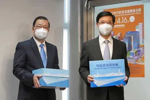 Former Hong Kong Chief Secretary John Lee, right, and his supporter Tam Yiu-chung, Hong Kong's representative to the Standing Committee of China's National People's Congress, pose for a photograph before submitting Lee's candidacy for the Election of the Chief Executive, in Hong Kong, Wednesday, April 13, 2022. Hong Kong’s former No. 2 official Lee said Wednesday he had formally registered his candidacy in the election for the top job after securing 786 nominations to enter the race.(AP Photo/