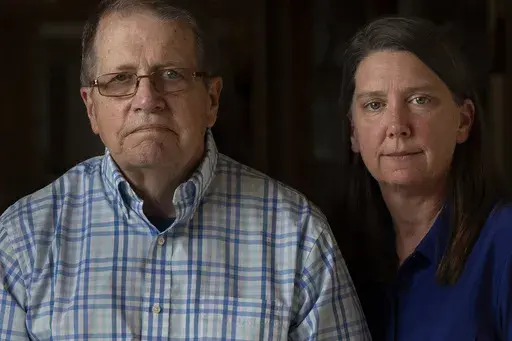 William Bortz, left, stands alongside his daughter, Ave Williams, at his senior living center, Friday, May 17, 2024, in San Diego. Bortz said criminals stole his family's nest egg of almost $700,000 in an elaborate scheme. Sophisticated overseas criminals are stealing tens of billions of dollars from Americans every year, a crime wave that's projected to get worse as the U.S. population ages and technology like AI makes it easier than ever to perpetrate fraud and get away with it. (AP Photo/Greg