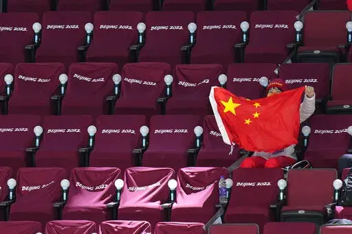 A spectator waves a Chinese flag during a preliminary round women's hockey game between China and Czech Republic at the 2022 Winter Olympics, Thursday, Feb. 3, 2022, in Beijing. (AP Photo/Petr David Josek)