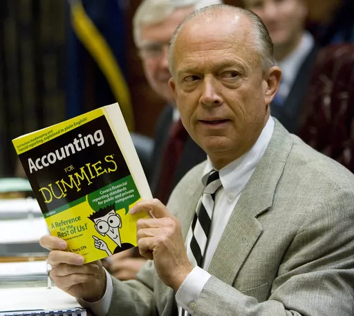 South Carolina Comptroller General Richard Eckstrom holds up a book he wanted to present to his new Chief of Staff James Holly during his introduction at the Budget and Control Board meeting, Aug. 13, 2009, in Columbia, S.C. Pressure is mounting for Eckstrom after a $3.5B accounting error. (AP Photo/Mary Ann Chastain, File)