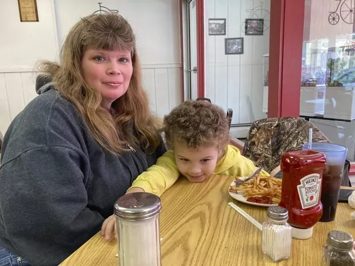 Heather Bable and her son Ashton poses for a photograph, Feb. 25, 2023 at Sprinklz On Top restaurant in East Palestine, Ohio. Bable and her children live less than a half-mile from where a train derailed in a fiery crash Feb. 3, forcing them to evacuate and raising fears about contamination of air, soil and water. Bable her family have lived in East Palestine for four generations but she says she no longer feels safe there and is seeking a new home. (AP Photo/John Flesher)