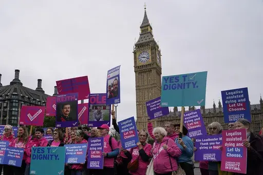A small demonstration by people advocating assisted dying hold a protest outside the Hoses of Parliament as a bill to legalise assisted dying is to be put before lawmakers in London, England, Oct. 16, 2024. (AP Photo/Alberto Pezzali, File)