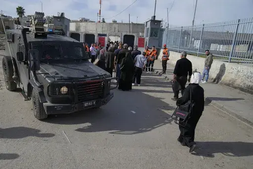 Palestinians cross from the Israeli military Qalandia checkpoint near the West Bank city of Ramallah to Jerusalem, to participate in the Friday prayers at the Al-Aqsa Mosque compound during the Muslim holy month of Ramadan on Friday, March 14, 2025. (AP Photo/Nasser Nasser)