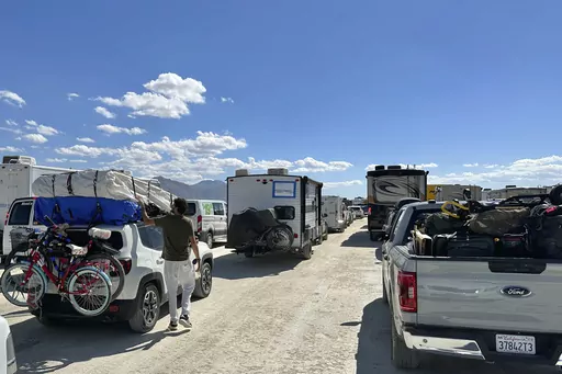 Vehicles line up in a several hour wait to leave the Burning Man festival in Black Rock Desert, Nev., Tuesday, Sept. 5, 2023. On Friday, Sept. 8, The Associated Press reported on stories circulating online incorrectly claiming officials confirmed an Ebola outbreak at the Burning Man festival and that a national emergency was declared. (AP Photo/Andy Barron, File)