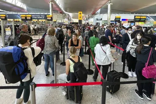 Travellers queue at security at Heathrow Airport in London, Wednesday, June 22, 2022. London’s Heathrow Airport  apologized Monday, July 11, 2022 to passengers whose travels have been disrupted by staff shortages. The airport warned that it may ask airlines to cut more flights from their summer schedules to reduce the strain if the chaos persists. (AP Photo/Frank Augstein, File)